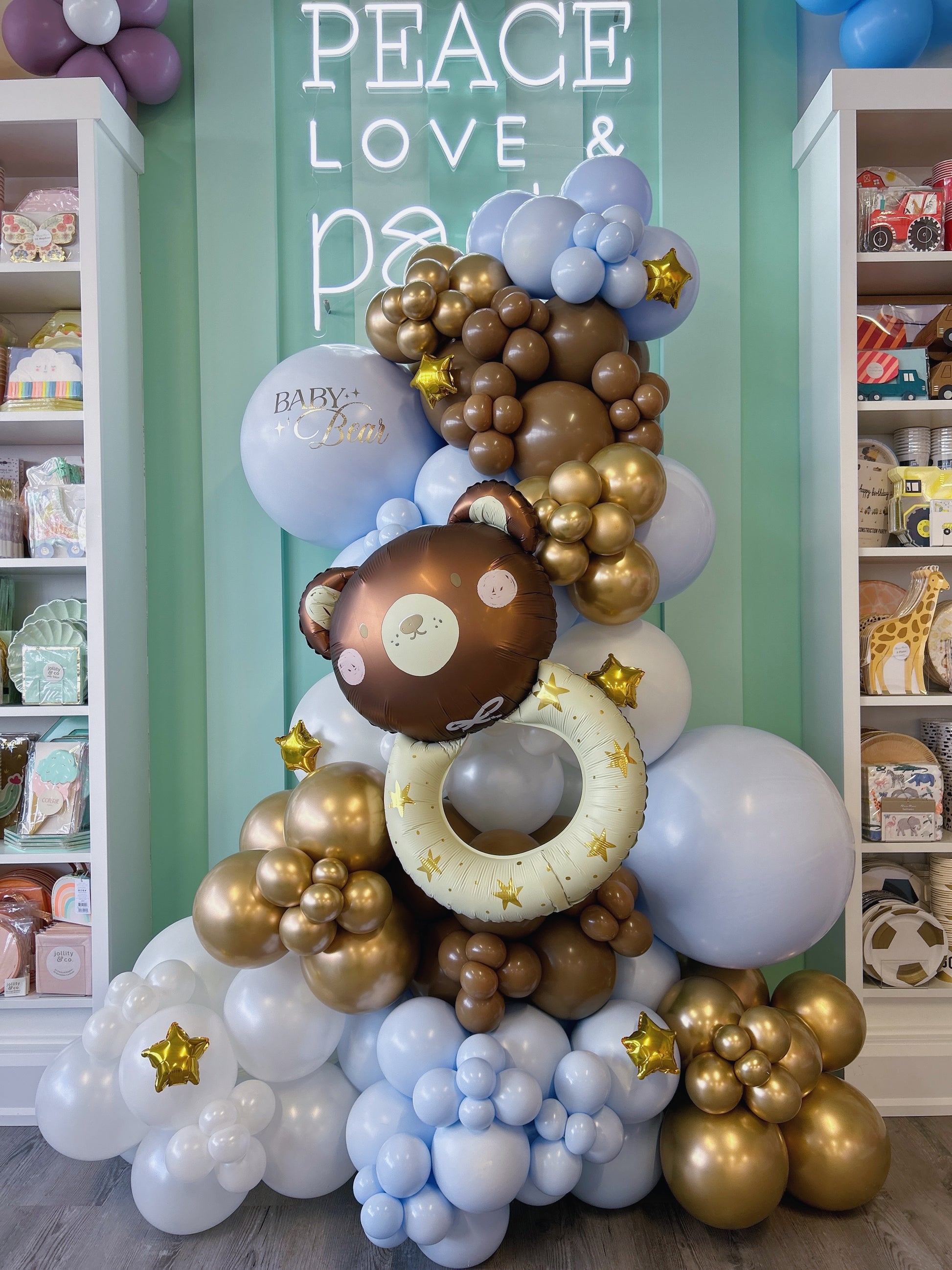 teddy bear balloon garland in chalk blue, mocha, pearl white and gold latex balloons featuring a baby bear rattle foil balloon