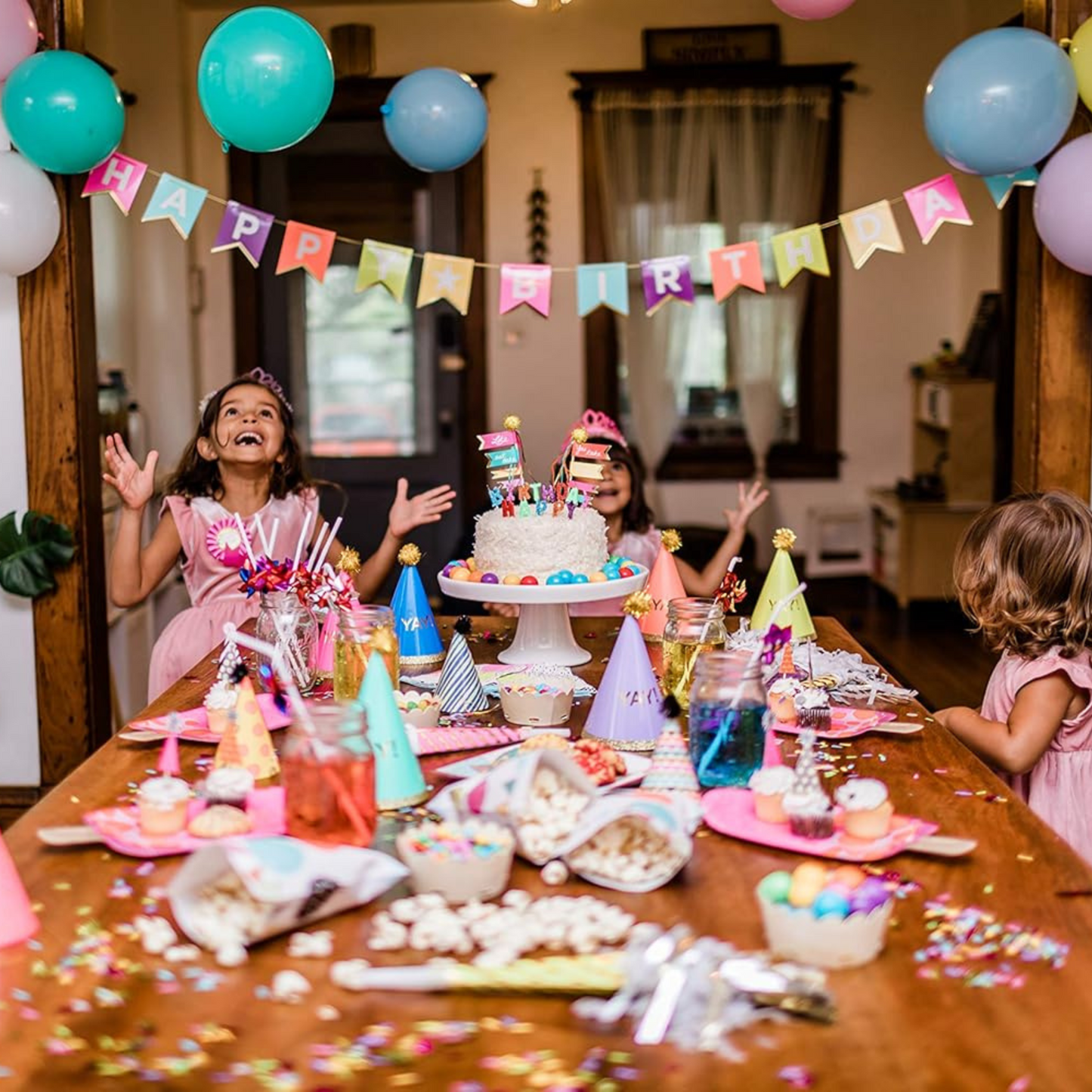 Children celebrating a birthday, eating cake with a "Happy Birthday" banner in the background