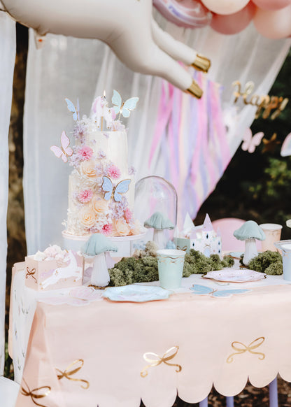 cow table cloth displayed with unicorn and butterfly themed party supplies