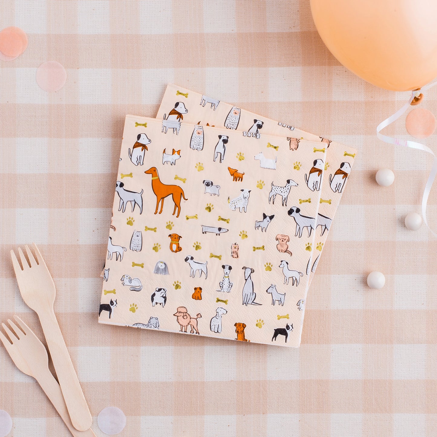 mixed dog printed napkin displayed on table with wooden cutlery and matching balloon