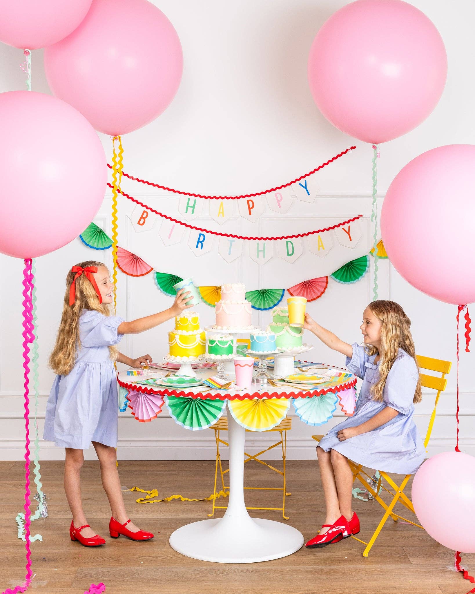 colourful birthday party display with balloons, hanging banner, and tablescape 