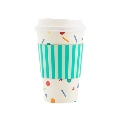 White paper to-go cup with a plastic lid, featuring a confetti sprinkle design and a striped teal sleeve.