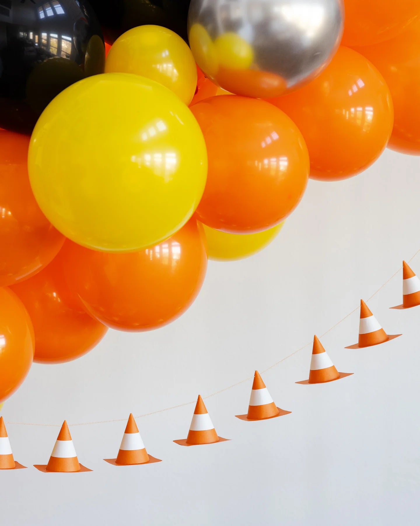 orange and yellow balloon garland with an orange pylon banner hanging below