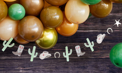 brown and gold balloon garland with western inspired paper banner hanging below