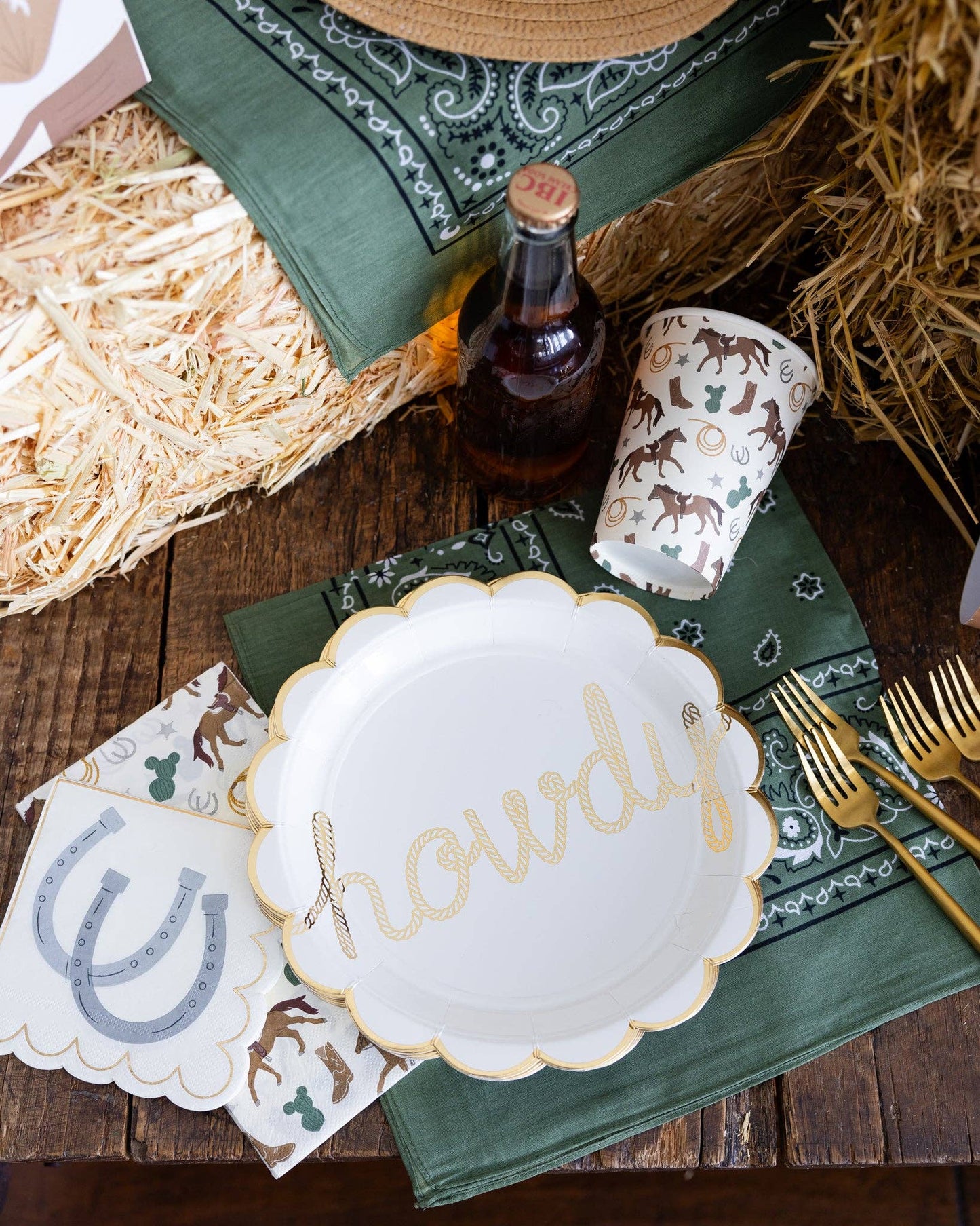 cowboy themed party supplies: cups, howdy plate, horseshoe napkins and green bandana 