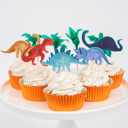 plate of cupcakes with white frosting, topped with different dinosaur toppers