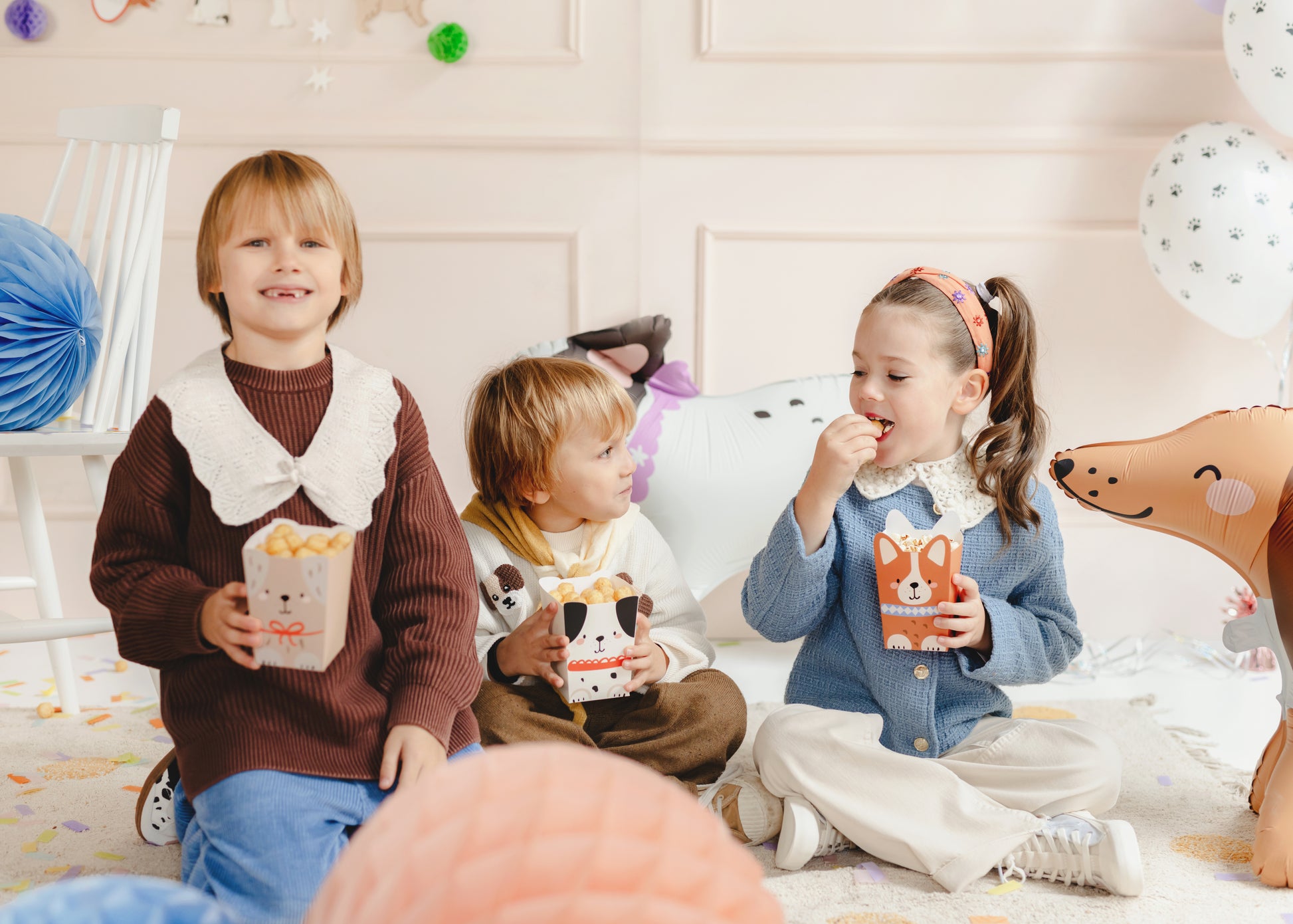 photo of kids eating out of puppy themed popcorn boxes 