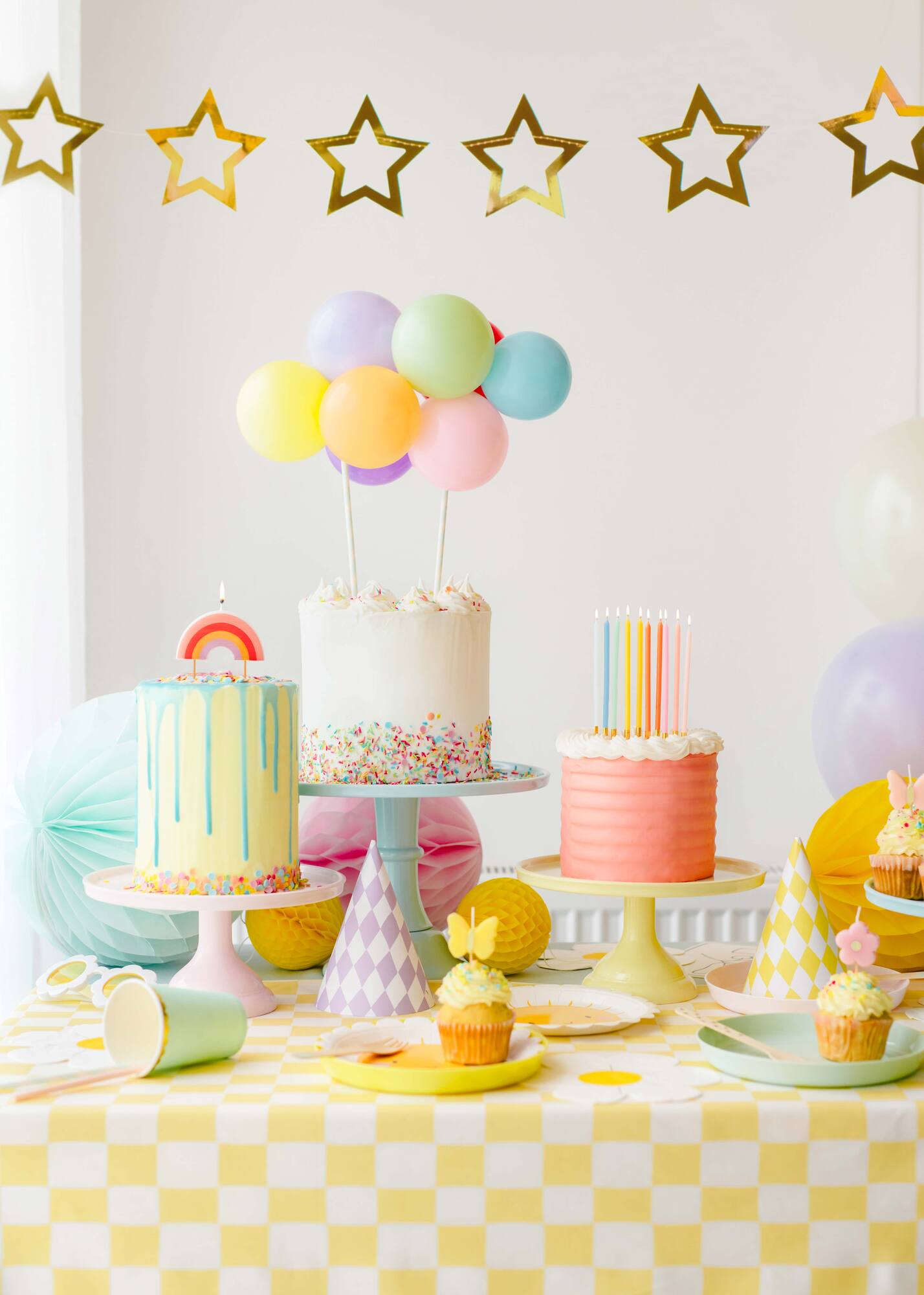 birthday table setup with 3 different birthday cakes and fun candles