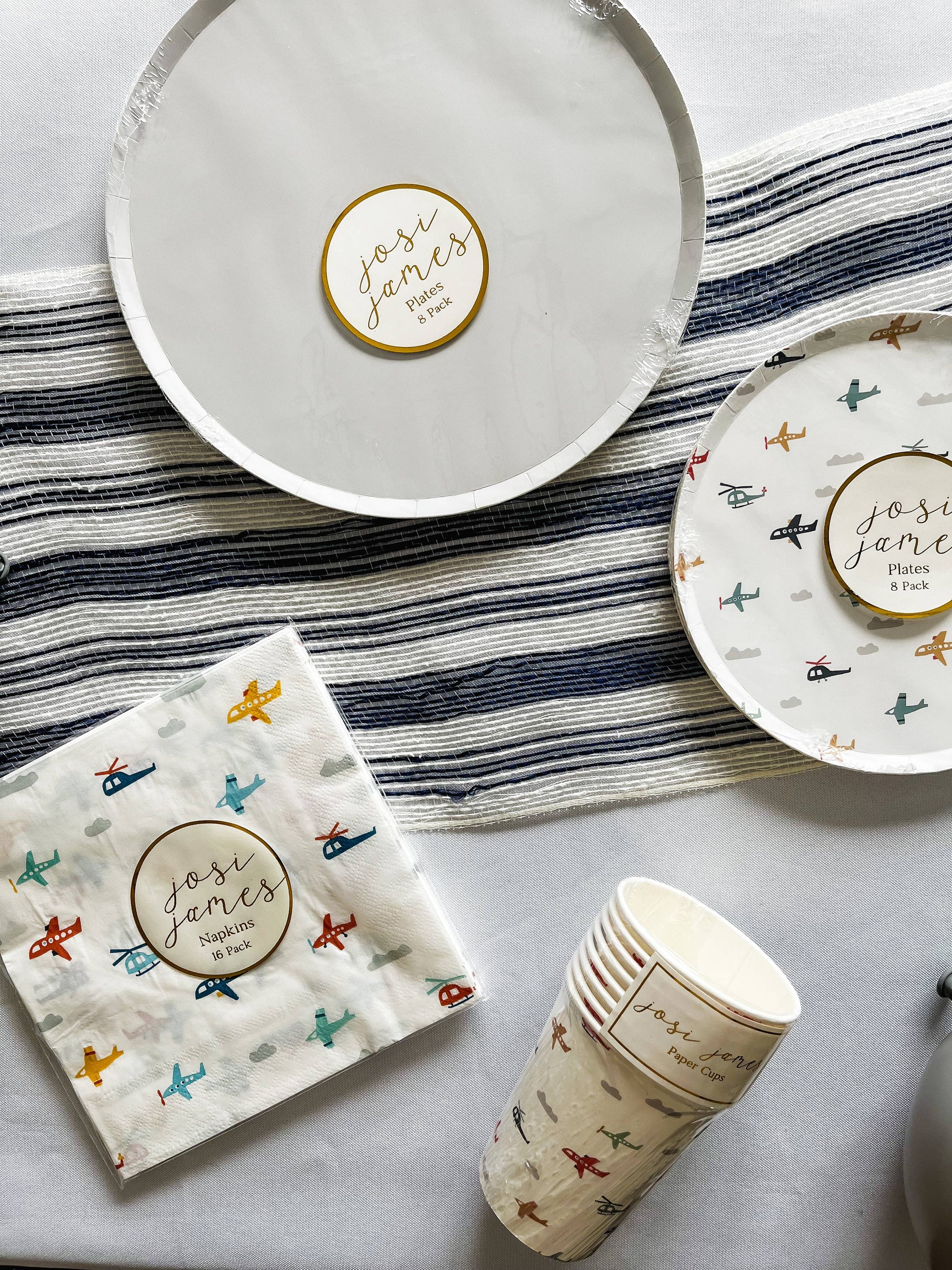 grey dinner plates paired with air plane  plates, cups and napkins 