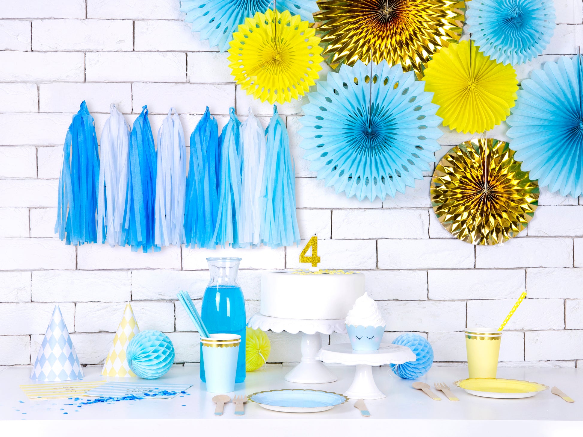 blue and yellow party supplies including tassel banner and hanging party fans