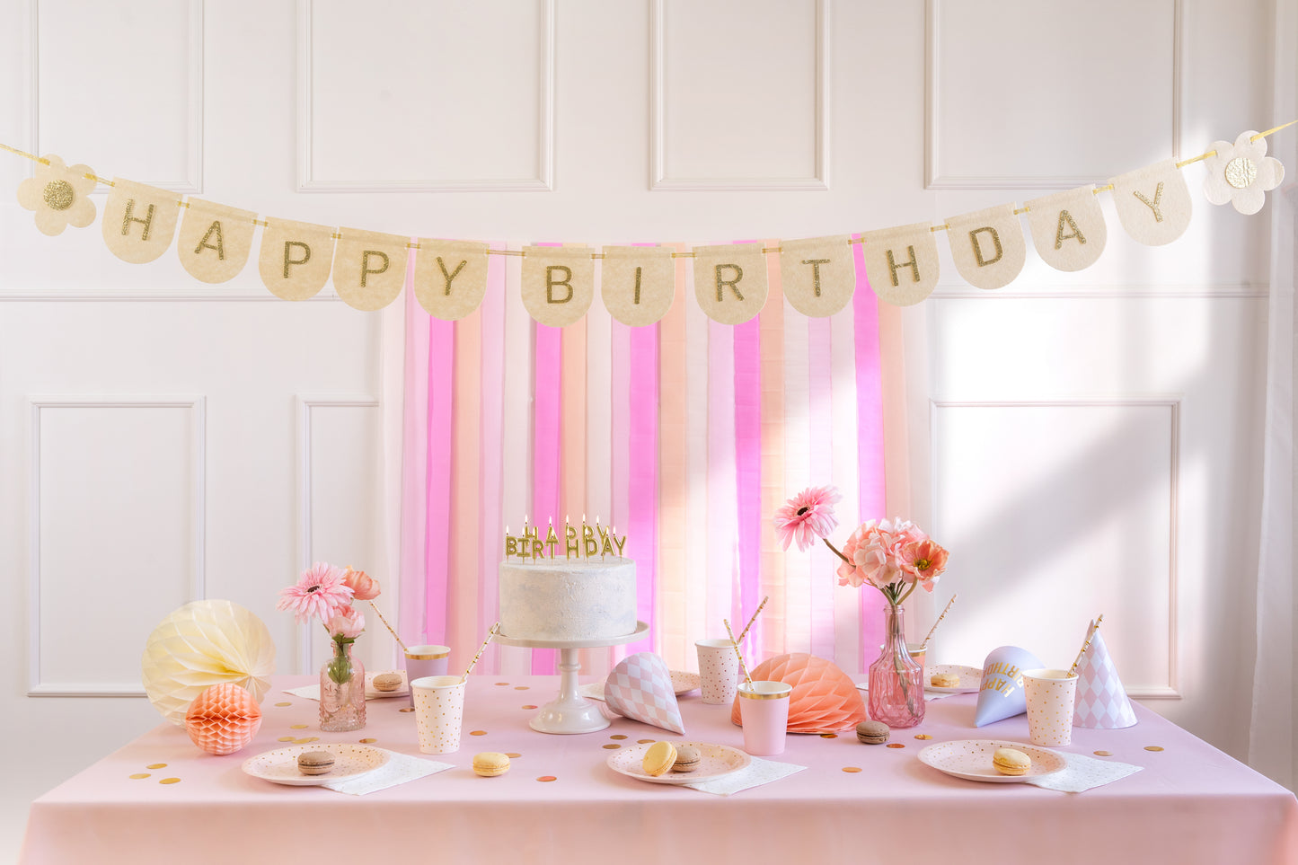 happy birthday banner hung on top on a cake table 