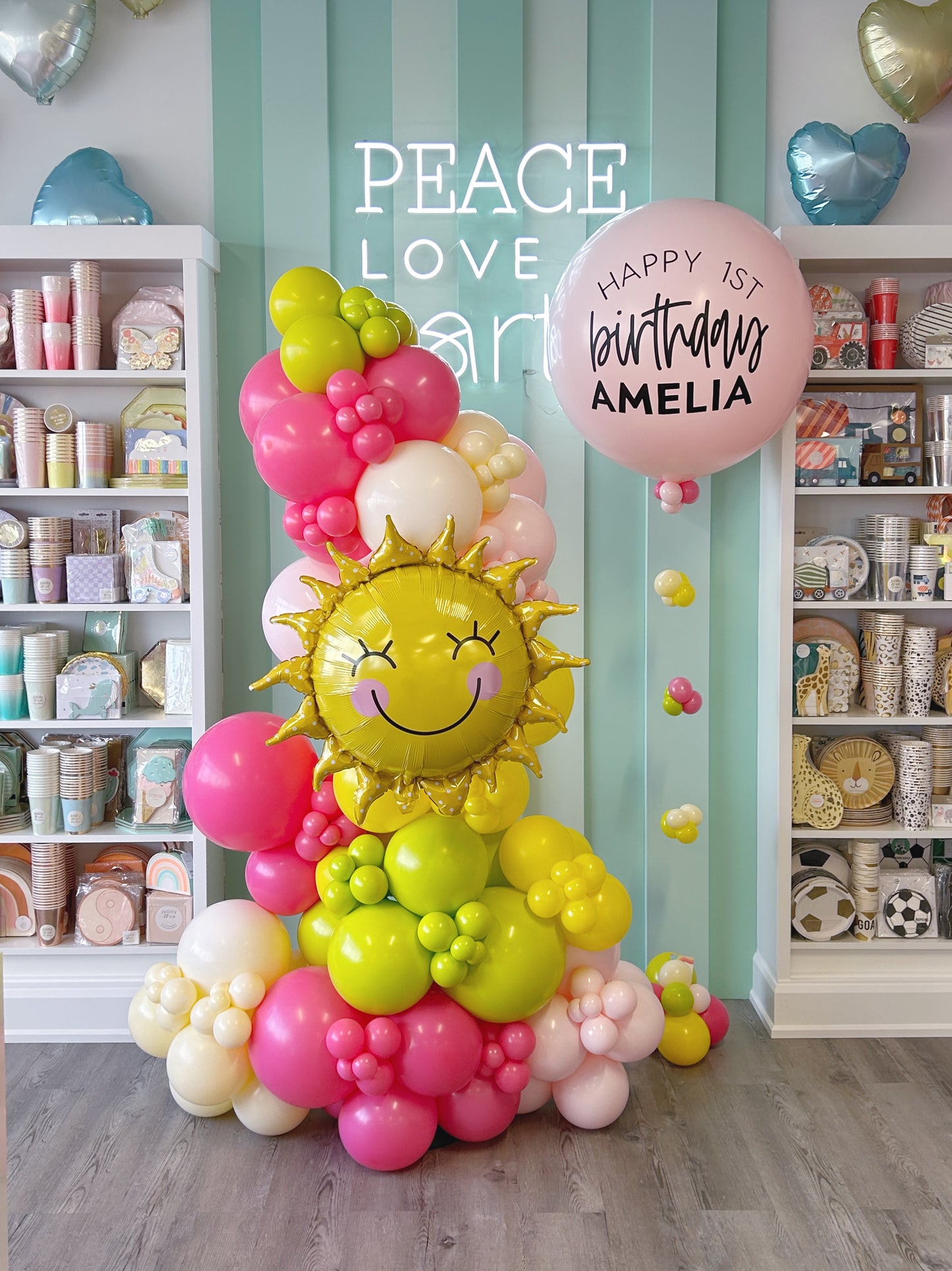 freestanding balloon garland featuring a sun foil balloon + a helium personalized jumbo balloon