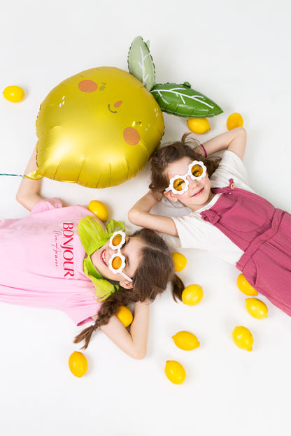 yellow lemon balloon with two girls wearing yellow daisy sunglasses