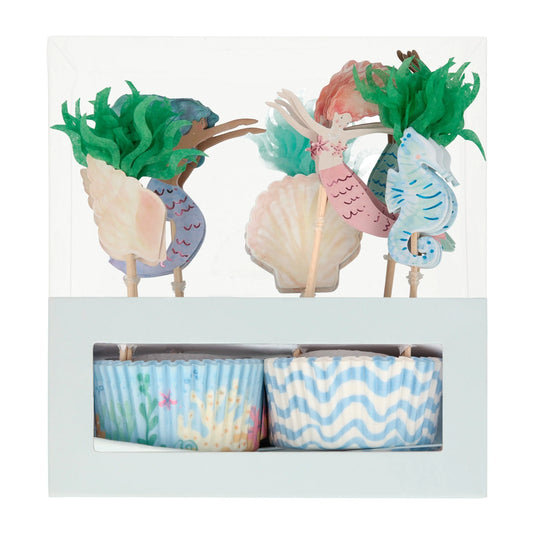 box of cupcake toppers and cases in a mermaid theme featuring mermaids, seahorses and sea shells