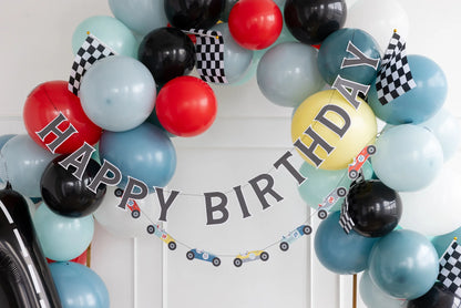 blue, red and black balloon arch with a hanging race car themed happy birthday banner