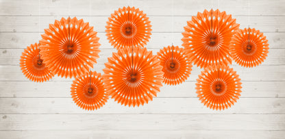 9 hanging orange paper fans in varying sizes