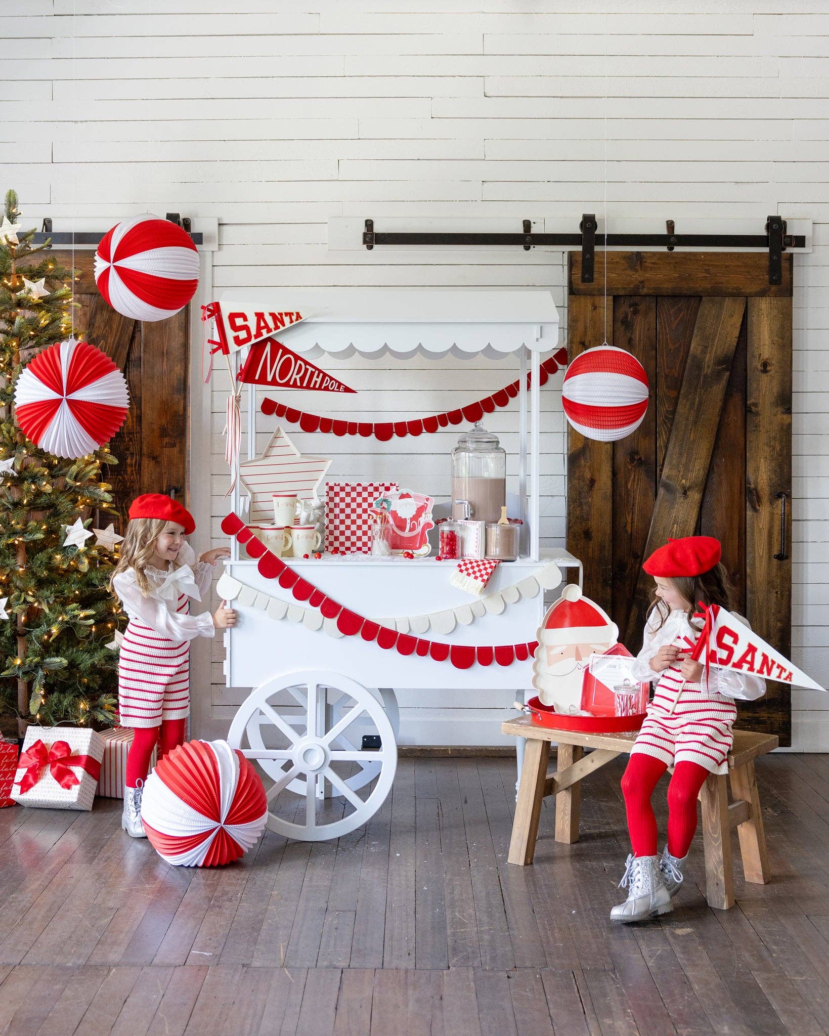 holiday sweet cart set up with different christmas themed party supplies 