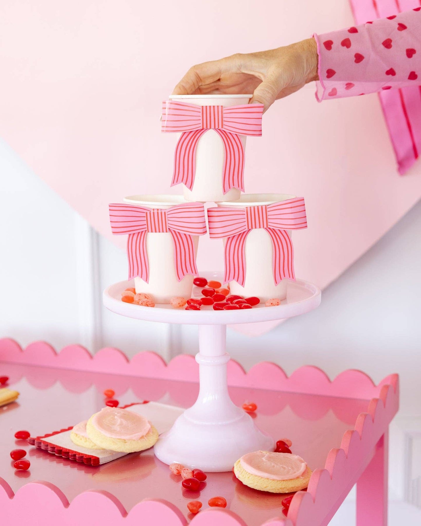 pink bow paper cups on cake stand with treats 