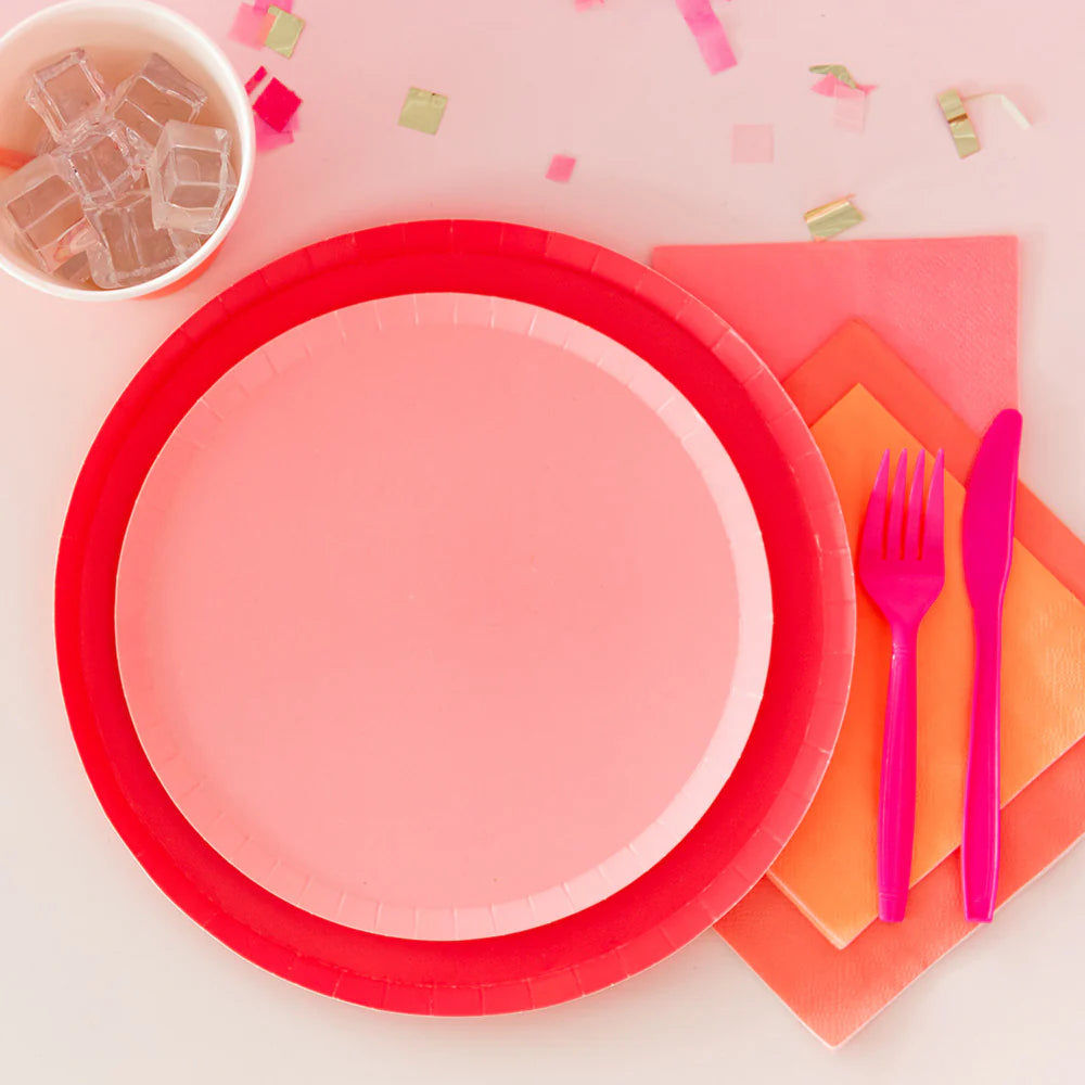 pink dessert plates paired with a red charger plate 