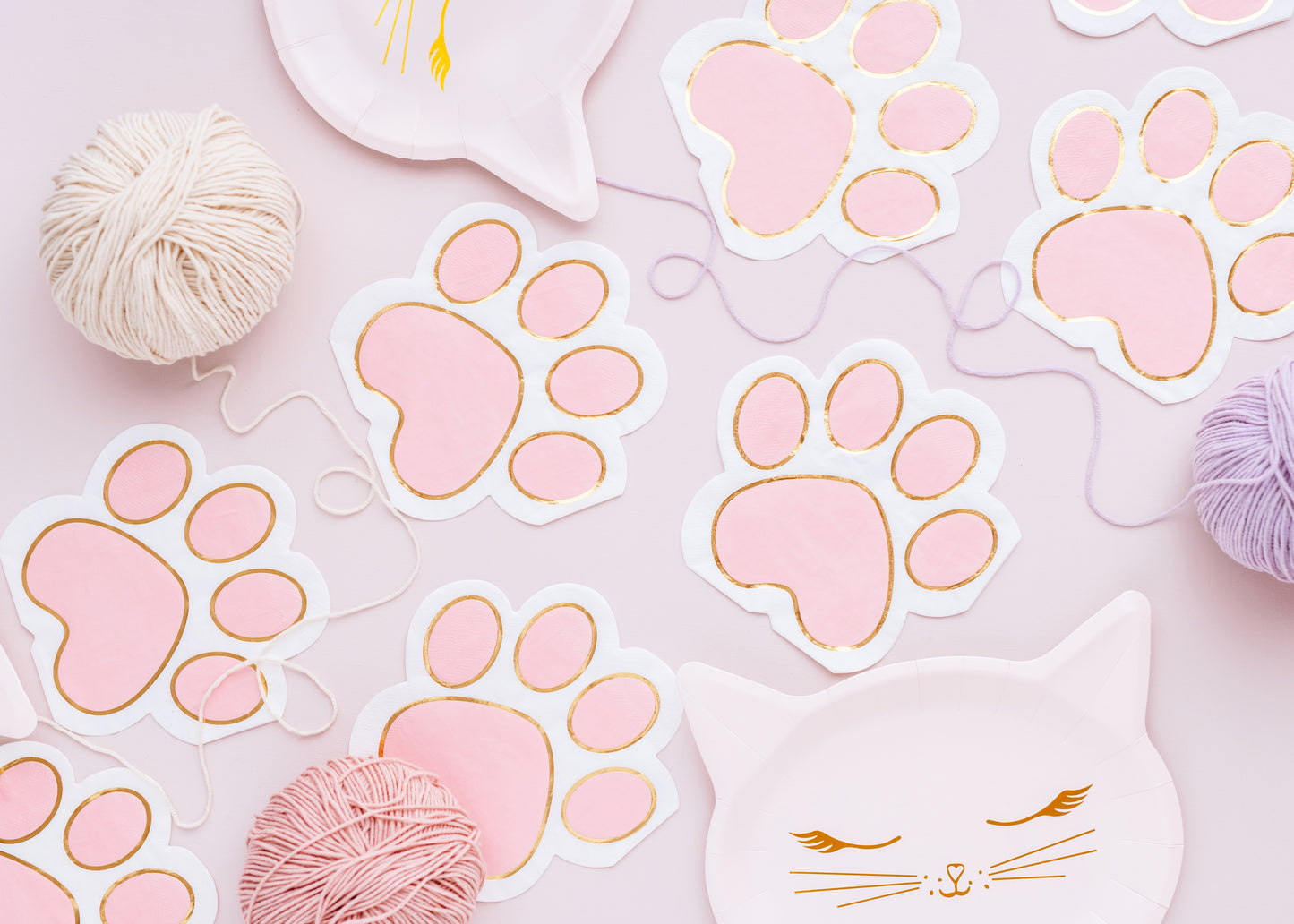 pink cat themed table setup with paw print napkins and cat shaped paper plates