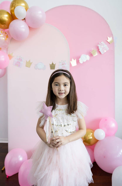 princess party supplies by my minds eye in Toronto - girl standing in front of balloon arch backdrop with princess hanging banner 