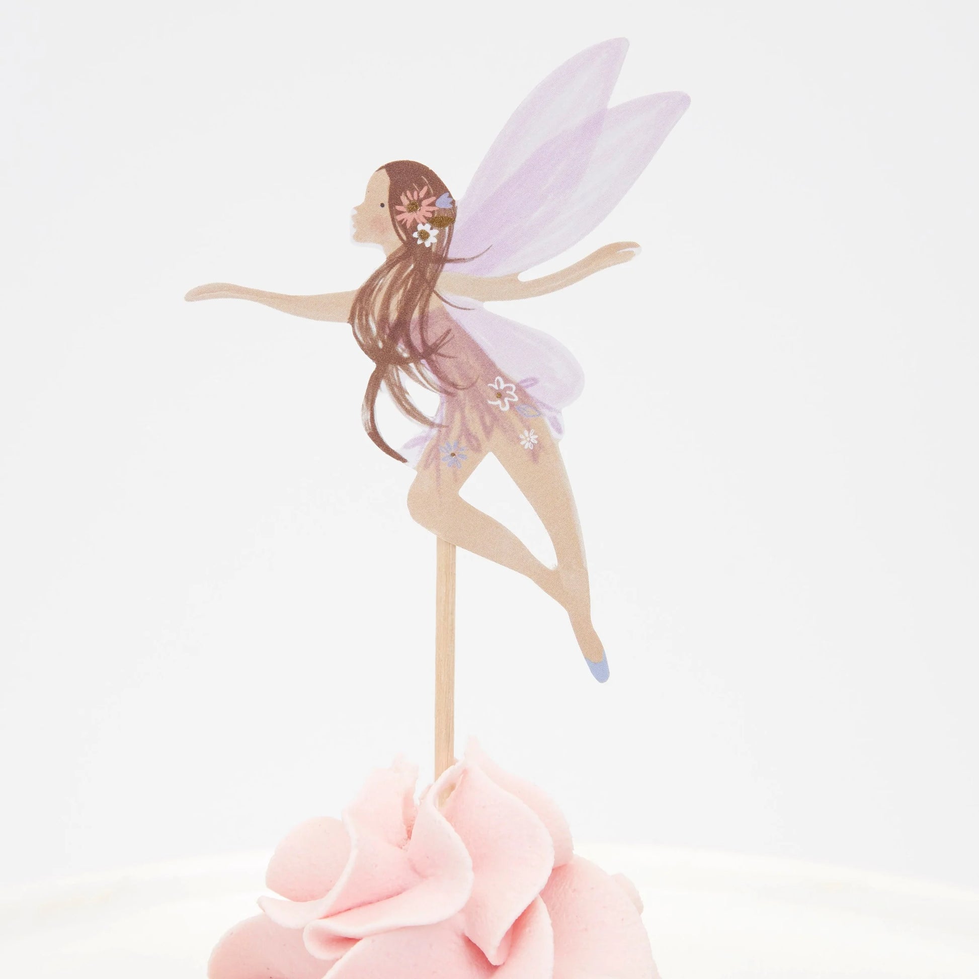 A cupcake with a fairy with purple wings on top of it.