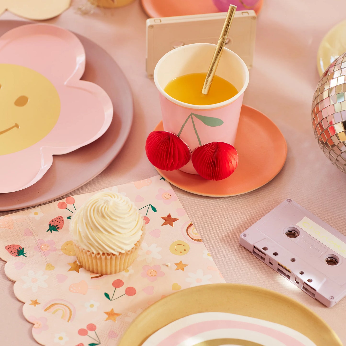 table setting with items from the happy icon collection include paper cups, plates and napkins