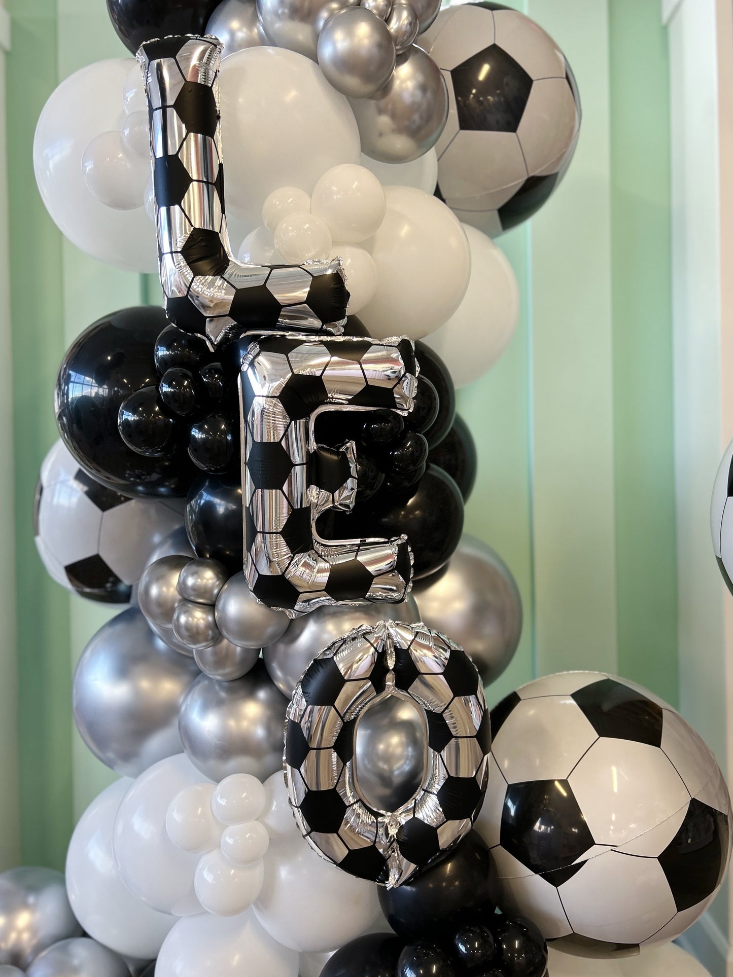 soccer ball mini balloon garland and foil letters with a soccer ball print 