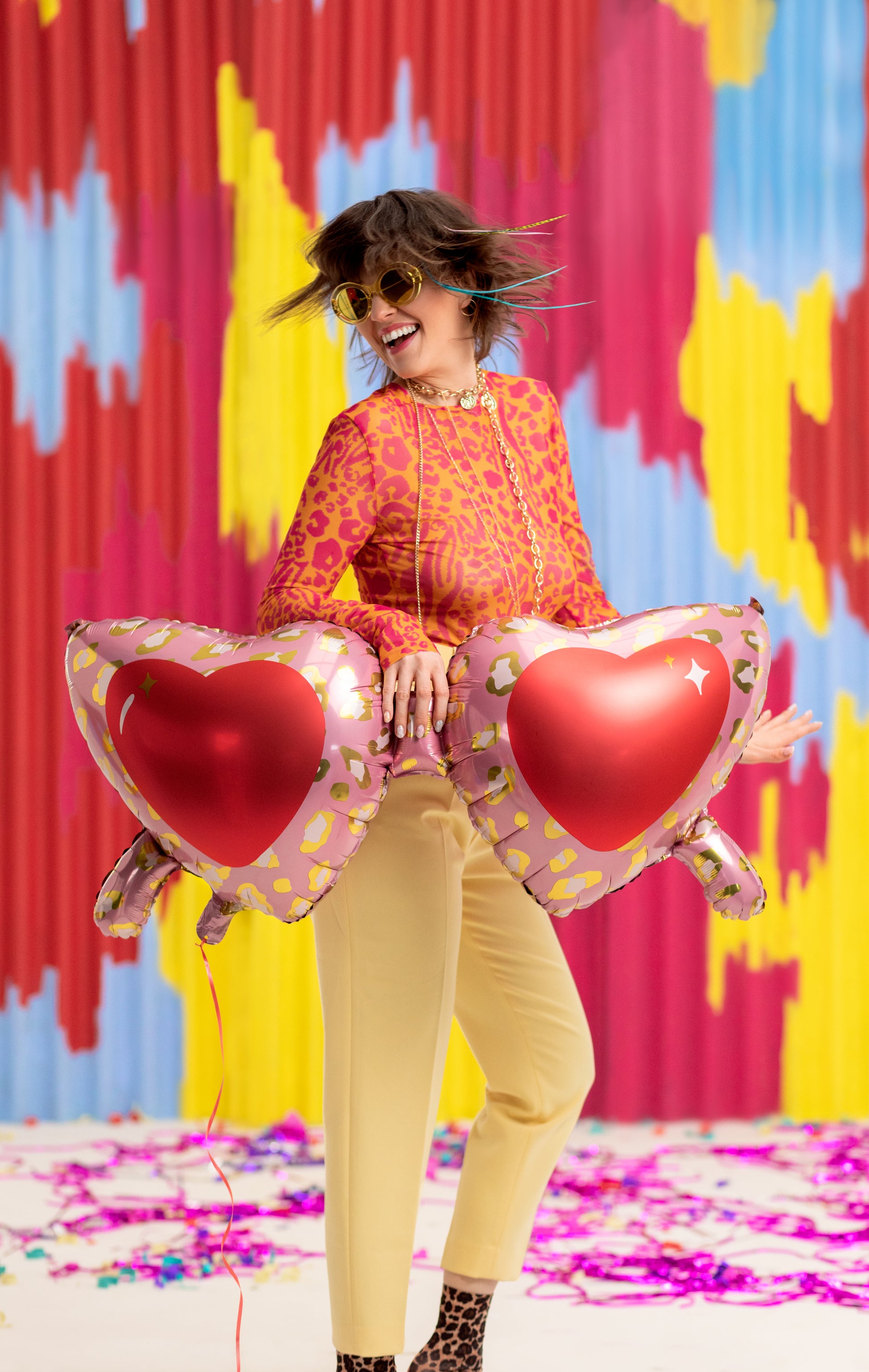 fun and wild girl holding the large sunglass shaped balloons