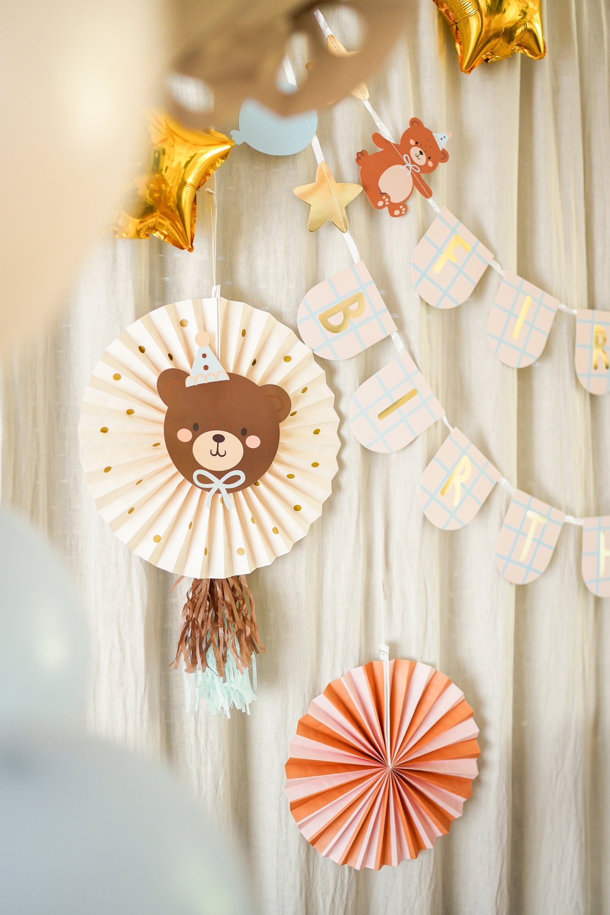 teddy bear rosettes set hanging with first birthday banner 