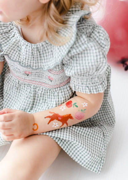 temporary horse tattoos on a little models forearm 