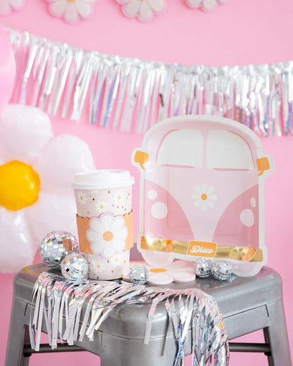 groovy inspired party decorations including a pink van shaped paper plate and daisy design paper to-go cup