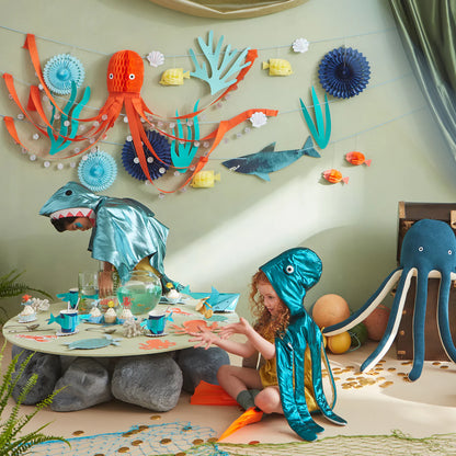 2 little children in costume playing in a party room decorated in an under the sea theme