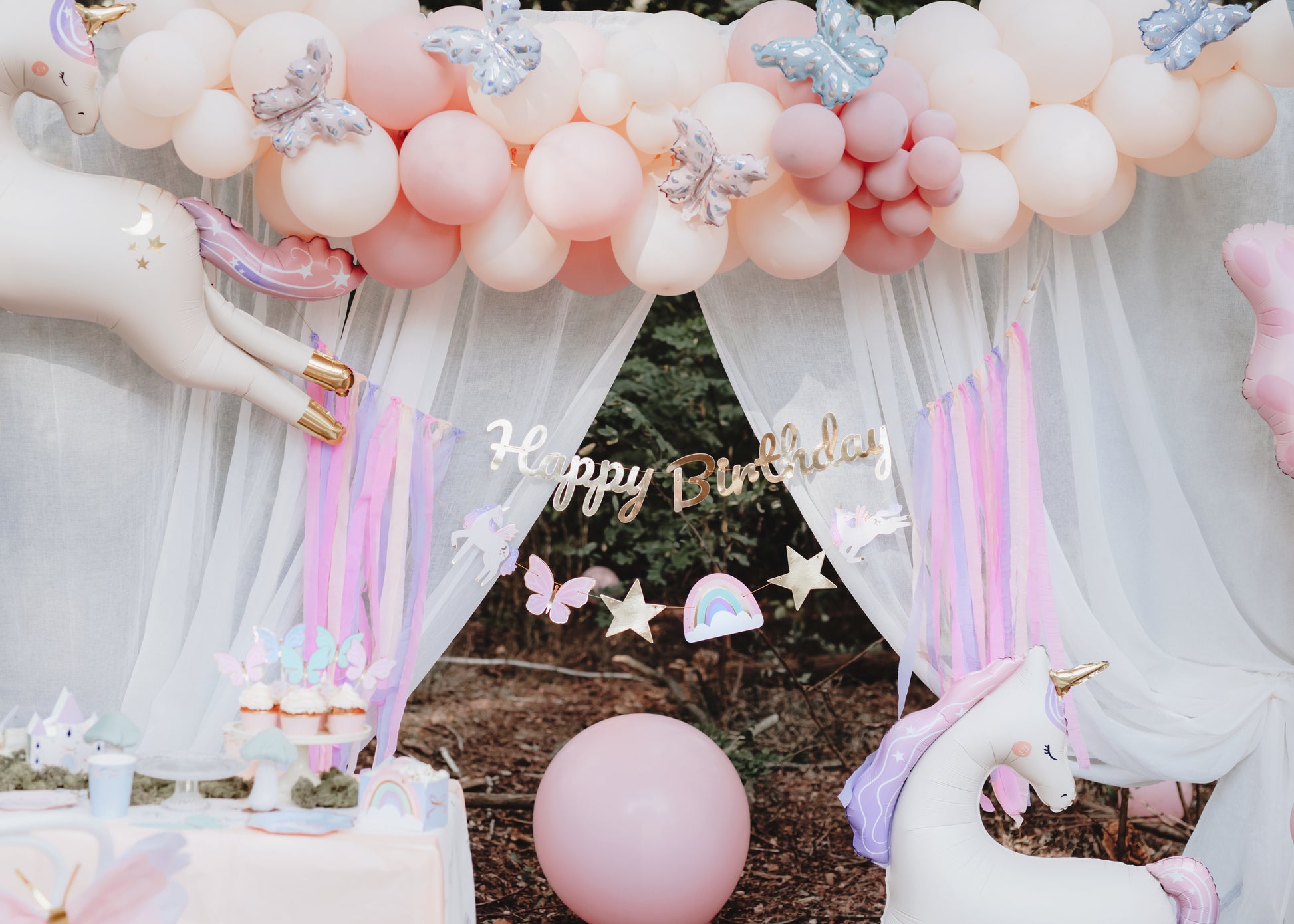 unicorn themed balloons, back drop and happy birthday banner 