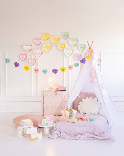 conversation hearts banner hung with teepee and matching pillows 